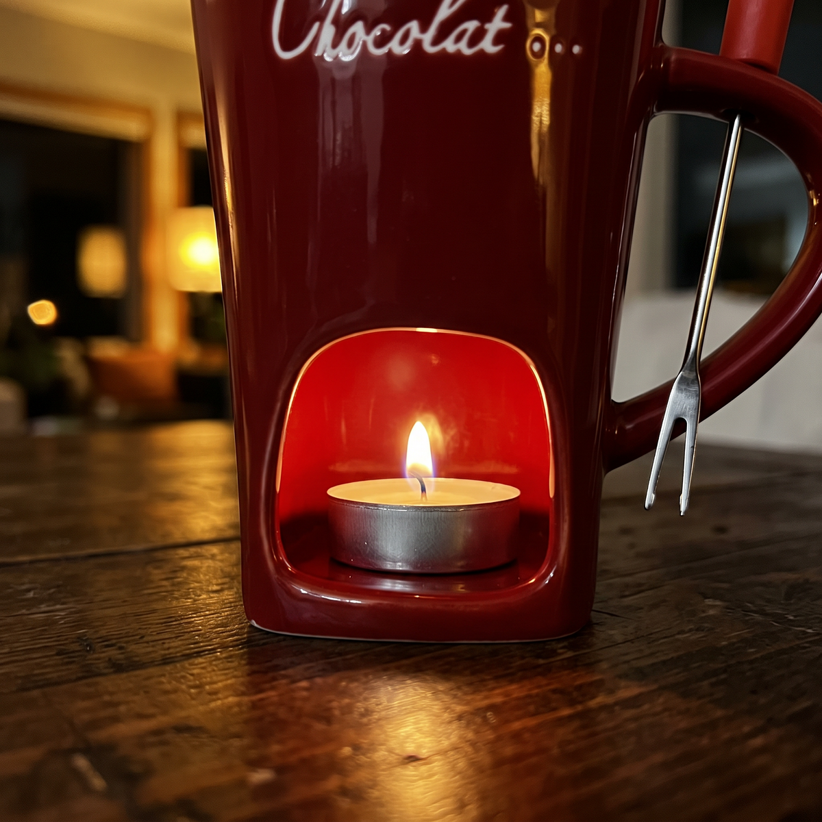Nahaufnahme der Teelicht-Öffnung der Mini-Fondue-Tasse mit brennendem Teelicht